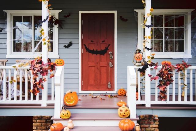 Porch and door of a house decorated in Halloween decorations.