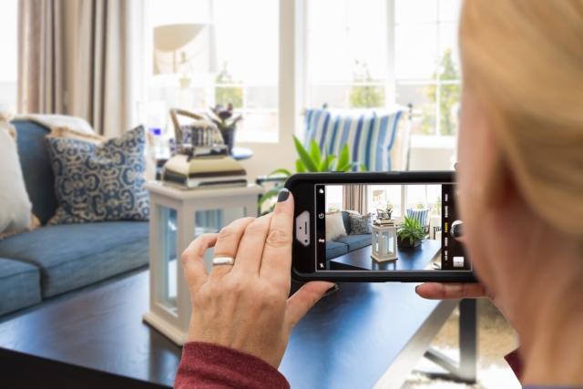 Woman photographing her rental property with her phone.