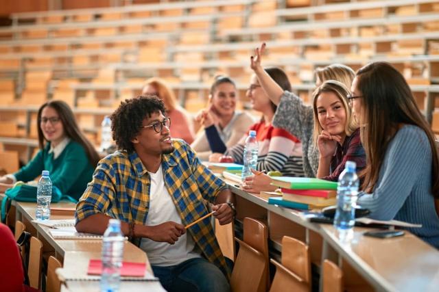 College students socialize in their lecture hall. 