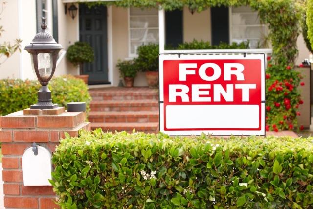 A for rent sign in front of a single family home