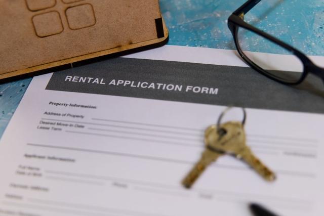 A pair of keys on top of a rental application form.
