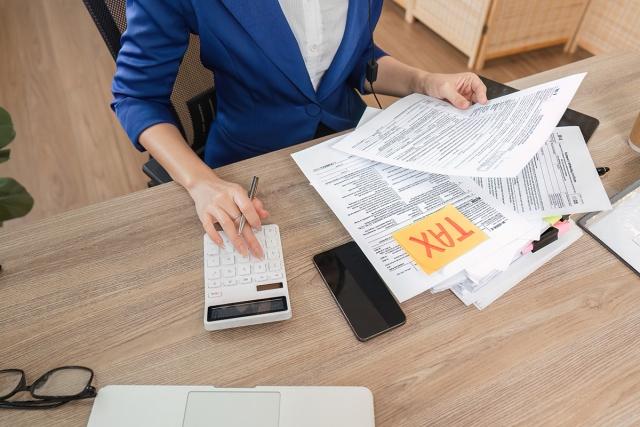 A professional woman using a calculator as she files taxes.