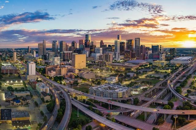 The skyline of Houston rises behind highways.