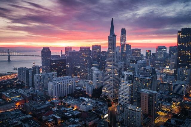 The San Francisco skyline glows as the sun sets.