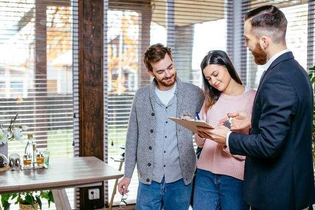 Couple signing a lease with a landlord.