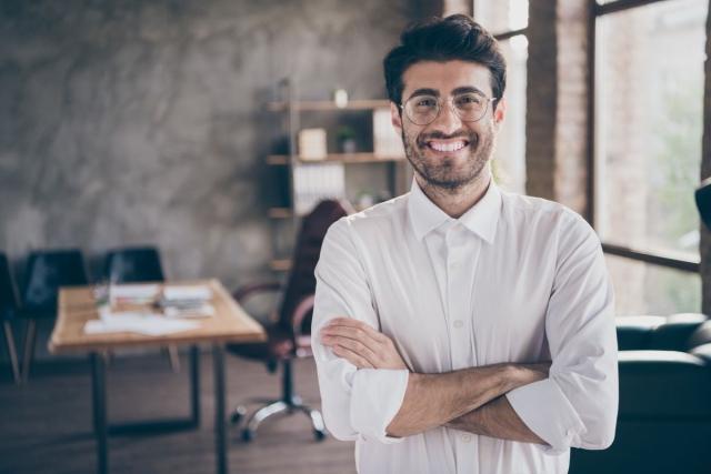 Person standing with arms folded looking satisfied