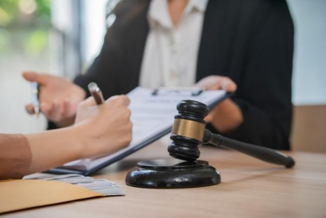 A lawyer and a client sign paperwork in a courthouse