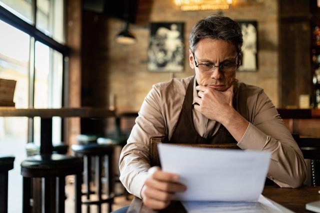 Man reading over papers by himself.