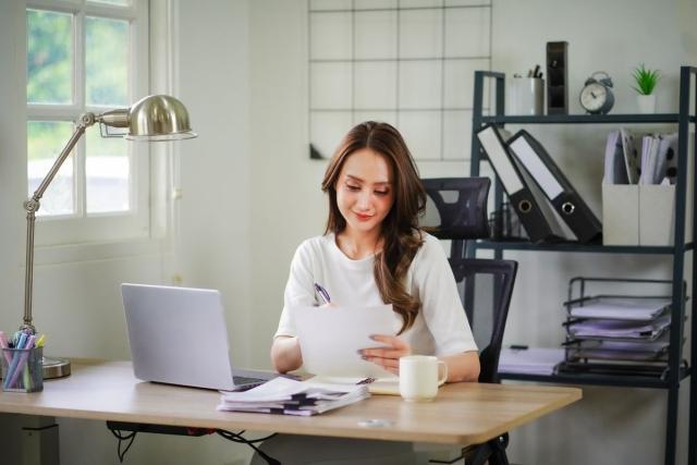 A lady sitting at a desk looking over paperwork