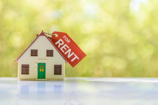 A tiny model house sitting on a table with a key chain on top