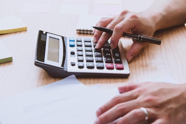A man's hand using a calculator