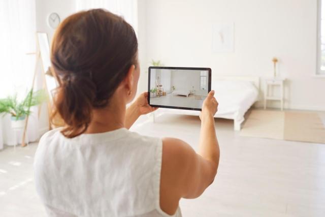 A property owner taking photos of a bedroom