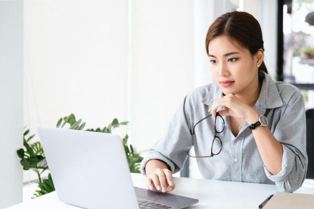 A woman in professional clothing using her laptop