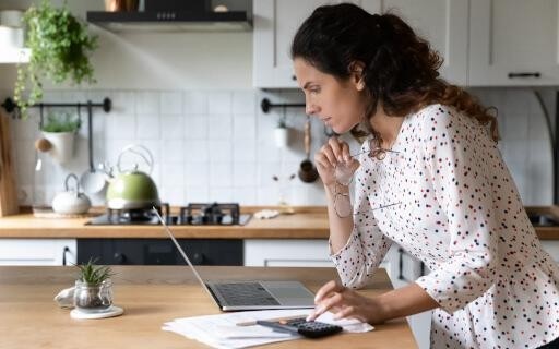 landlord reviewing laptop screen from their kitchen counter