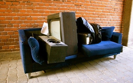 tenant abandoned couch, speakers, television in an otherwise empty apartment