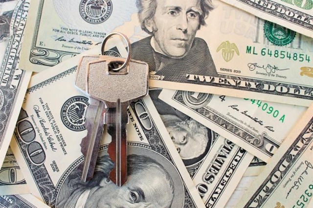 a set of apartment property keys atop twenty dollar bills