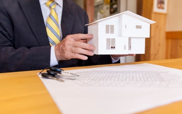 Person holding model house