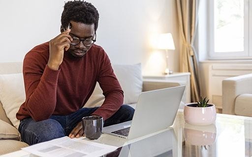 Man staring pensively at a laptop screen