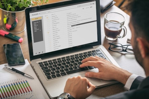 Person writing an email on their laptop.