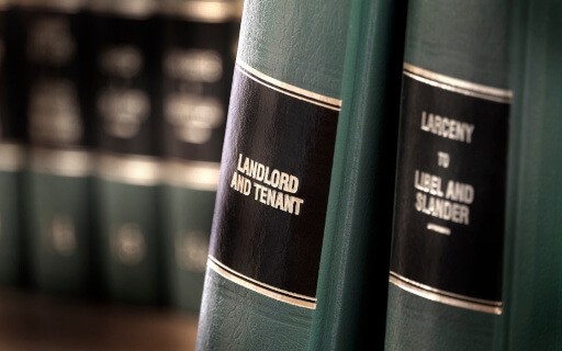 Textbook about landlord and tenant laws sits on a bookshelf.