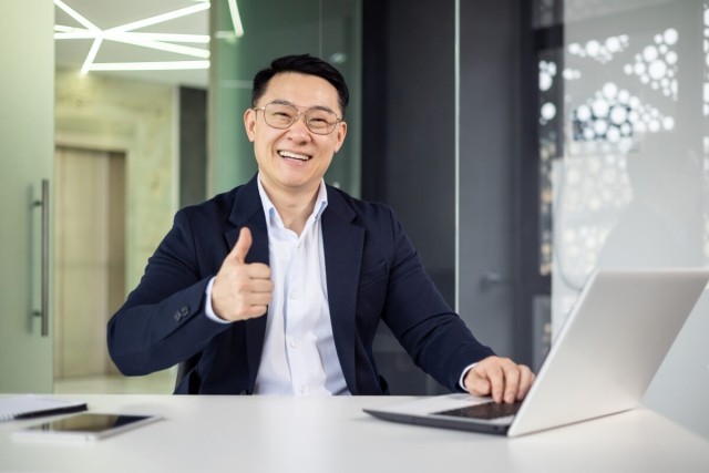 Landlord using computer gives a thumb's up