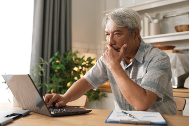 Landlord looking at his computer screen trying to make a decision