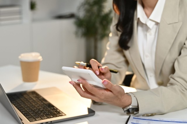 Landlord holding a calculator in her hand