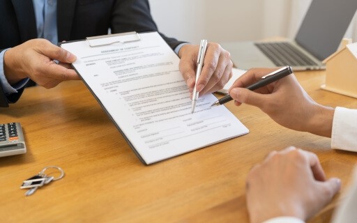 A landlord points out policies and fees on a lease.
