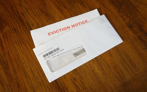 An eviction notice letter on a wood table.