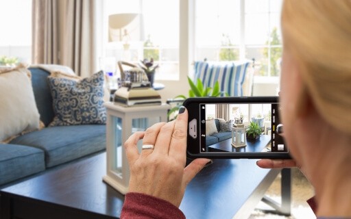Woman photographing her rental property with her phone.