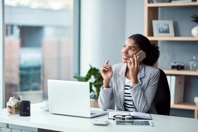Landlord sitting at desk talking on her phone