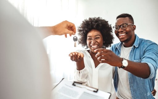 Landlord handing tenant home keys.