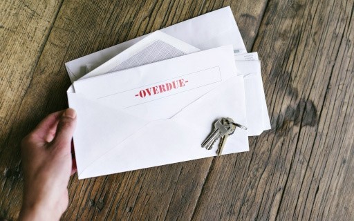 A person holds an overdue bill.