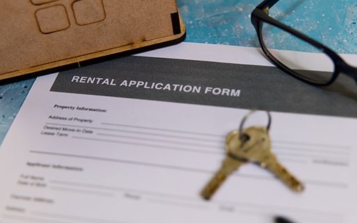 A pair of keys on top of a rental application form.