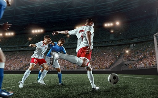 Soccer players in a packed full stadium.