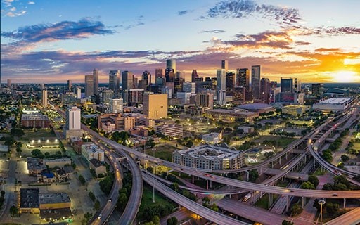 The skyline of Houston rises behind highways.