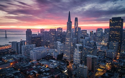 The San Francisco skyline glows as the sun sets.