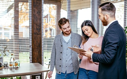 Couple signing a lease with a landlord.