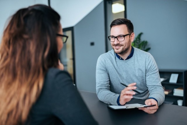 landlord holds an application while speaking to a tenant