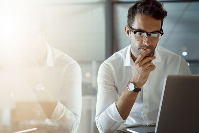 Man using a laptop trying to make a decision