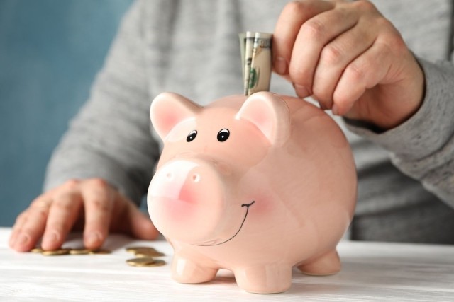 A person putting money in a piggy bank
