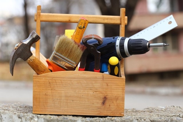A wooden toolbox with various handyman tools