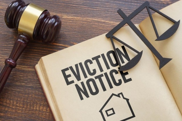 A judge's gavel sitting next to a legal book on eviction notices