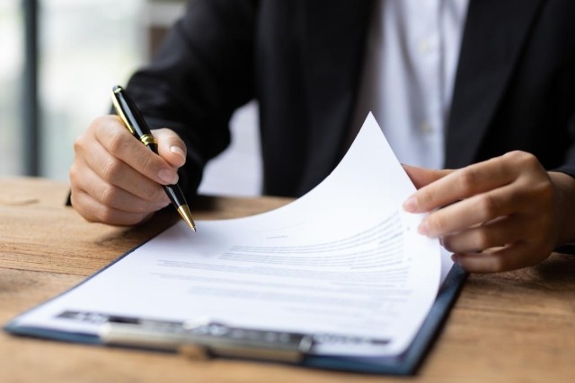 A business person sitting at a desk looking at a document