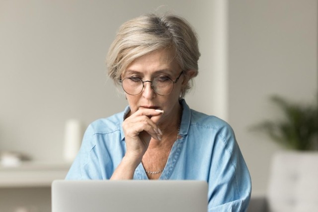 Woman sitting in front of her computer trying decide what to do