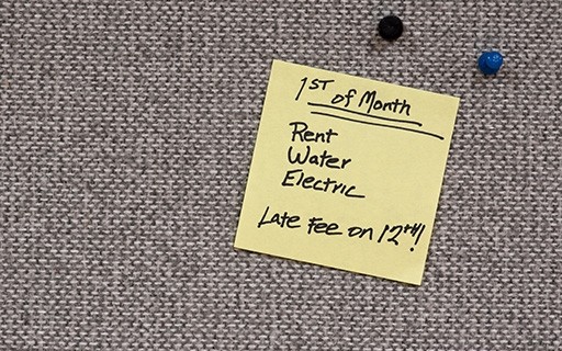 A yellow sticky note reads that rent, water, and electric bills are due the 1st of the month, and late fees are assessed on the 12th.