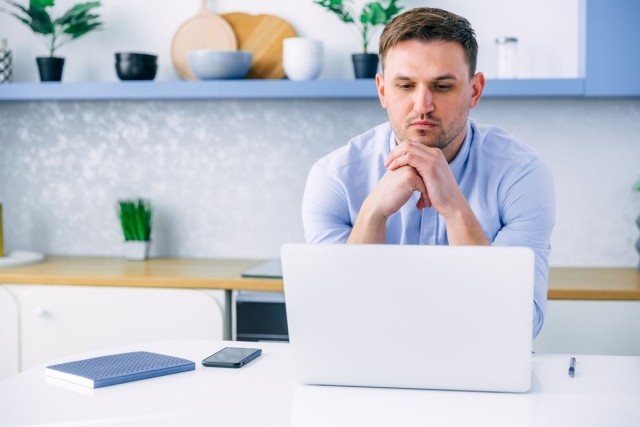 A man staring at his laptop trying to make a decision