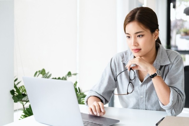A woman in professional clothing using her laptop