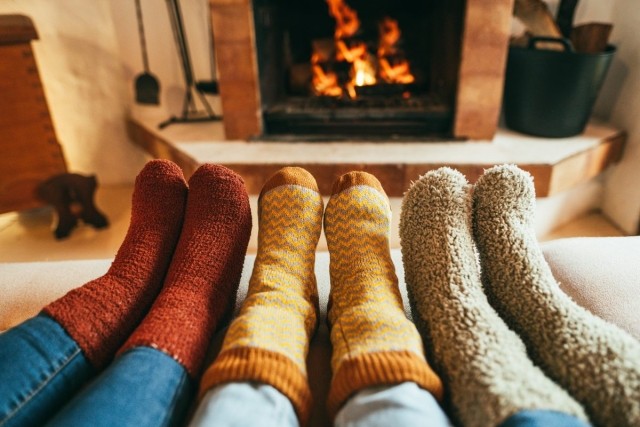 Socked feet in front of a warm fireplace